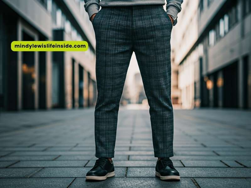 A man wearing a grey and black checked suit stands on a street, highlighting the trend of plaid pants.