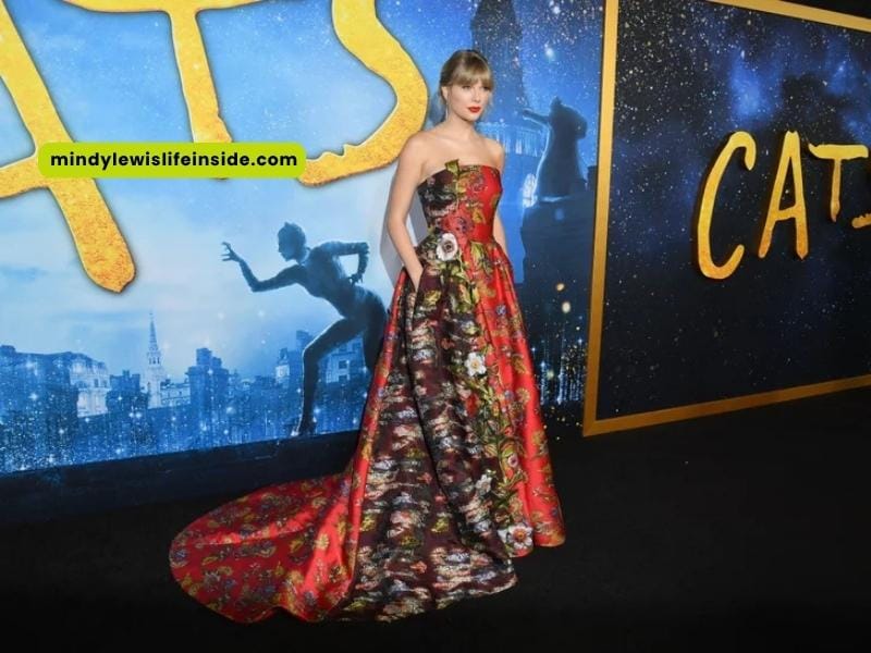 Taylor Swift attends the "Cats" world premiere, looking stylish on the red carpet with fans and photographers around her.