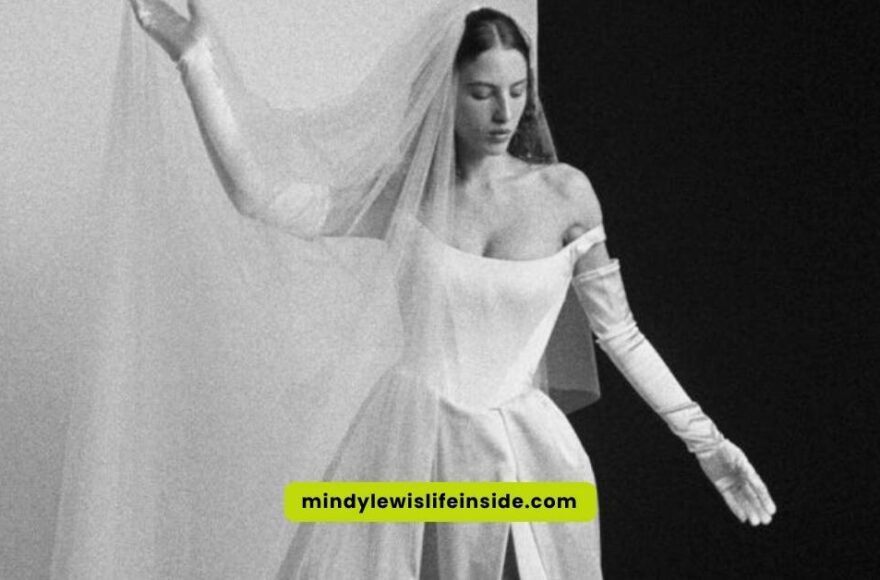 A woman in a stunning Vivienne Westwood wedding dress poses elegantly for the camera, showcasing intricate design details.