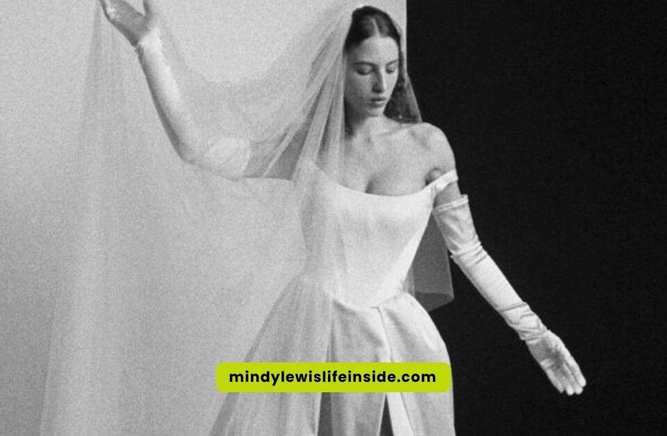 A woman in a stunning Vivienne Westwood wedding dress poses elegantly for the camera, showcasing intricate design details.
