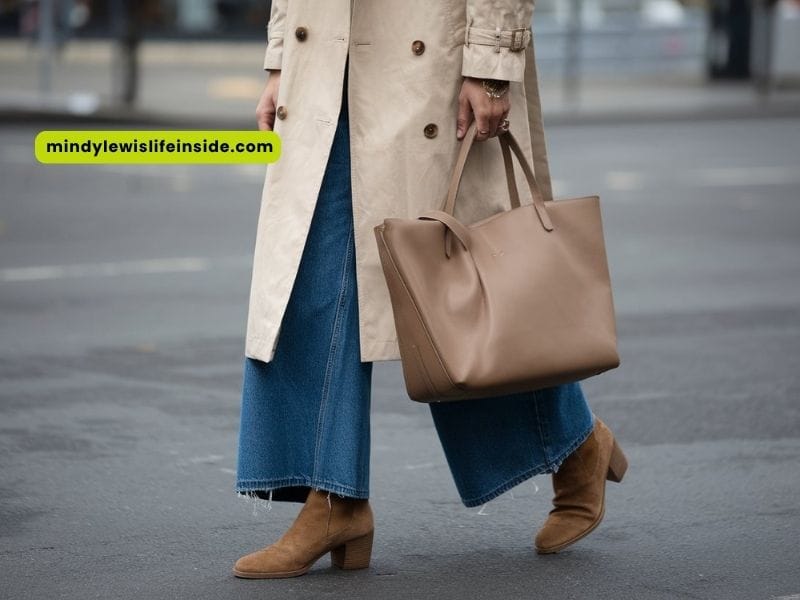 A woman in wide leg jeans and a trench coat poses, highlighting her fashionable look and casual style.