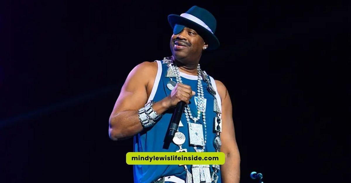 On stage, a man in a blue shirt and hat captivates the audience, reminiscent of Slick Rick's iconic eyepatch look.