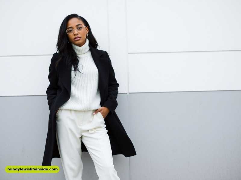 A woman wearing white pants and a black coat, showcasing a stylish winter outfit for Black girls.