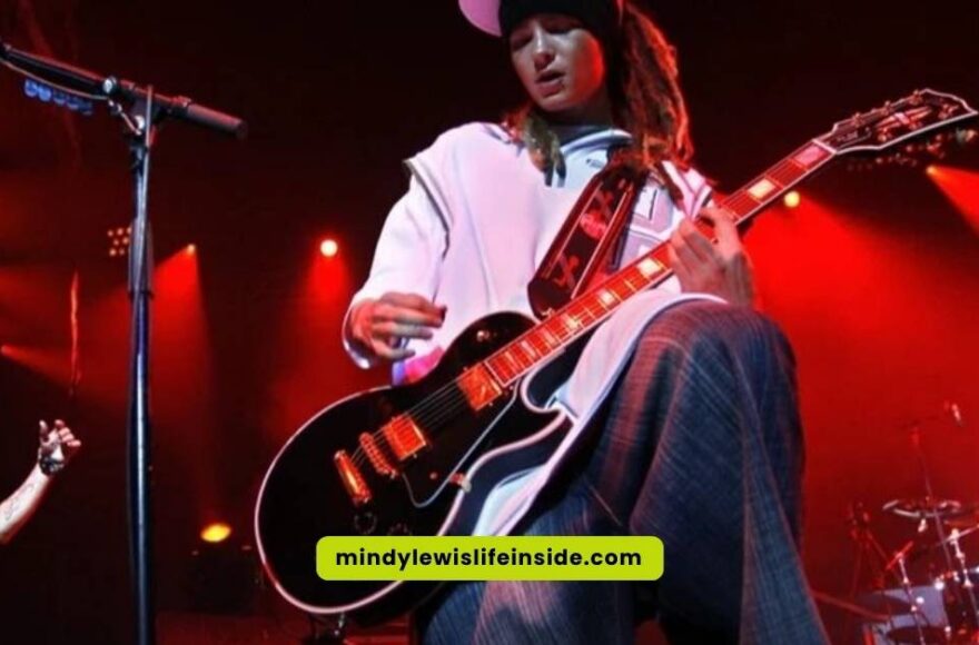A guitarist performing on stage with another man, both contributing to an engaging live music experience.