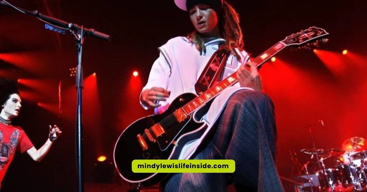 A guitarist performing on stage with another man, both contributing to an engaging live music experience.