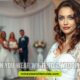 A bride in a white wedding dress stands in a serene setting, symbolizing the tradition of wearing white at weddings.