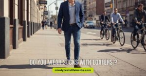 A stylish man in a suit and loafers, pondering whether to wear socks with his loafers.