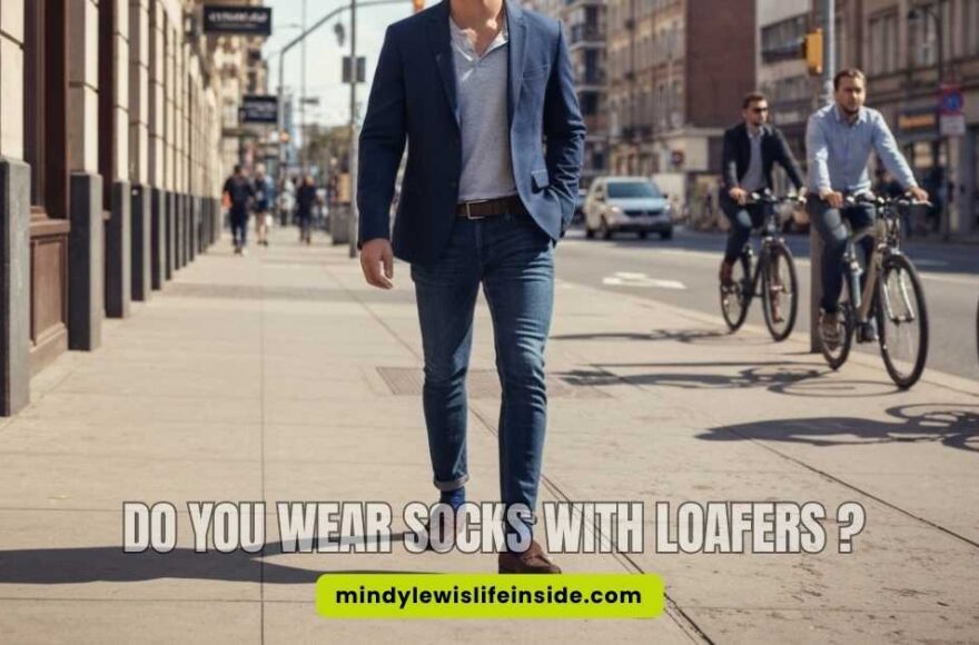 A stylish man in a suit and loafers, pondering whether to wear socks with his loafers.