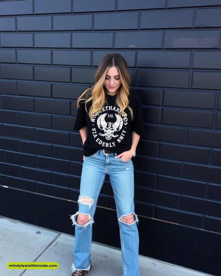 A woman in ripped jeans and a black t-shirt, showcasing a stylish outfit for a concert.