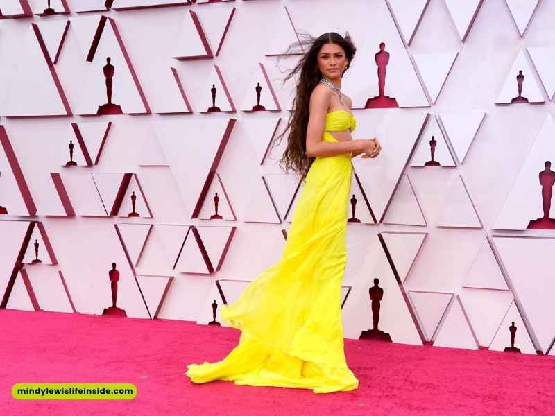 Individual in a vibrant yellow gown at the Oscars, exemplifying a stylish and elegant celebrity event look.